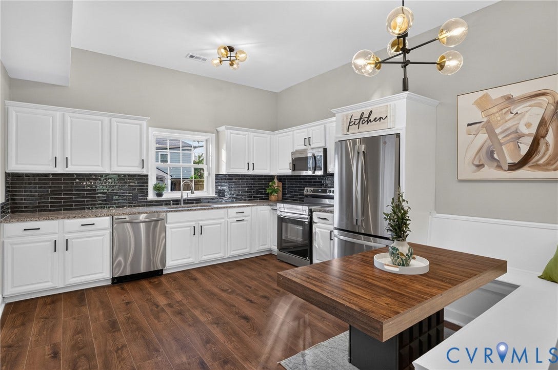 526 N 33rd Street, Church Hill, Richmond, VA 23223 Kitchen featuring LVP-finish flooring, white cabinetry with black hardware, stainless steel appliances, dark subway tile backsplash, and light-colored countertops