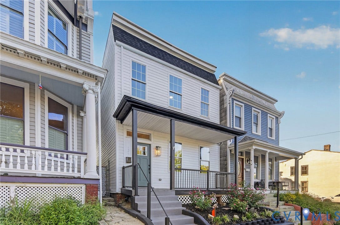 526 N 33rd Street, Church Hill, Richmond, VA 23223 Two-story facade with horizontal siding, covered porch, black railing, and exterior lighting fixtures