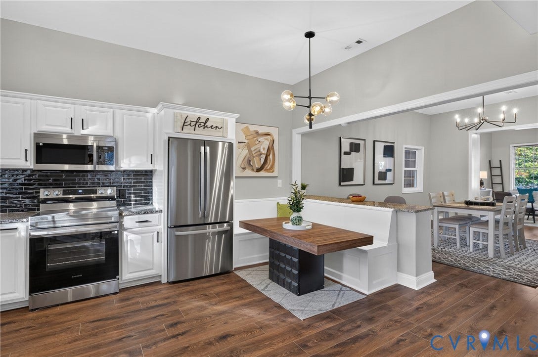 526 N 33rd Street, Church Hill, Richmond, VA 23223 White cabinetry with modern hardware, stainless steel appliances, dark subway tile backsplash, wood-finish flooring, and vaulted ceiling