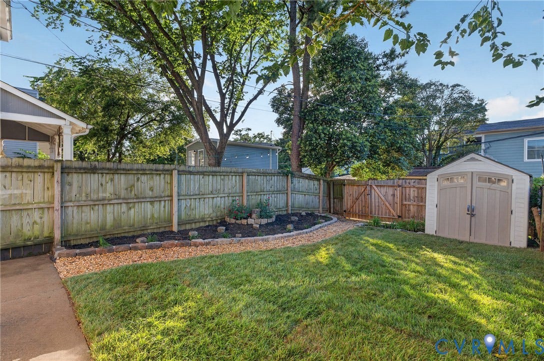 526 N 33rd Street, Church Hill, Richmond, VA 23223 Fenced backyard with a manicured lawn, a gravel pathway, and a built-in storage shed