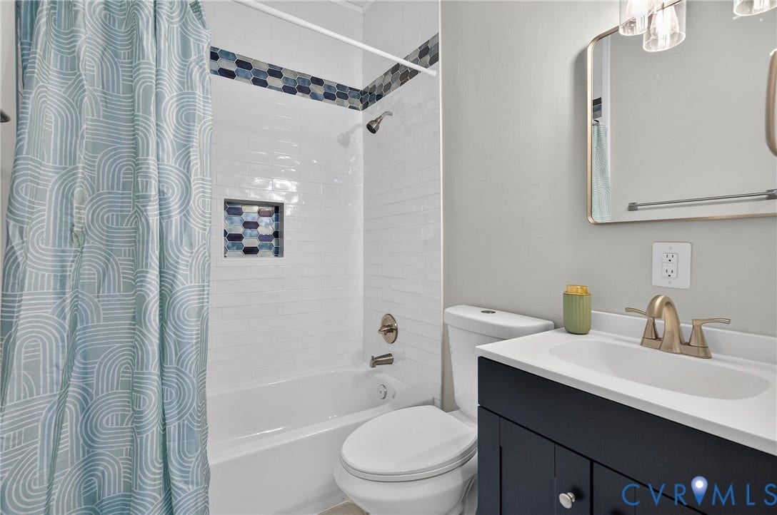 526 N 33rd Street, Church Hill, Richmond, VA 23223 Hall Bathroom, White subway tile tub surround with mosaic accent, built-in shower niche, dark wood-finish vanity with white countertop, and brushed nickel fixtures