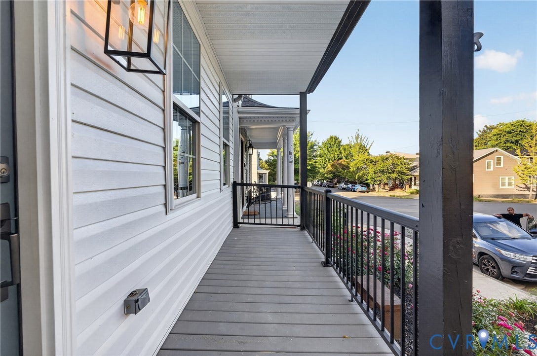 526 N 33rd Street, Church Hill, Richmond, VA 23223 Covered front porch featuring white siding, dark wood-finish columns, black metal railings, and a wood-finish floor