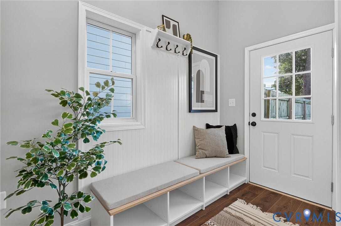526 N 33rd Street, Church Hill, Richmond, VA 23223 Mudroom featuring LVP-finish flooring, a white paneled storage bench with cushions, a white paneled wall, a double-hung window, with back door to yard