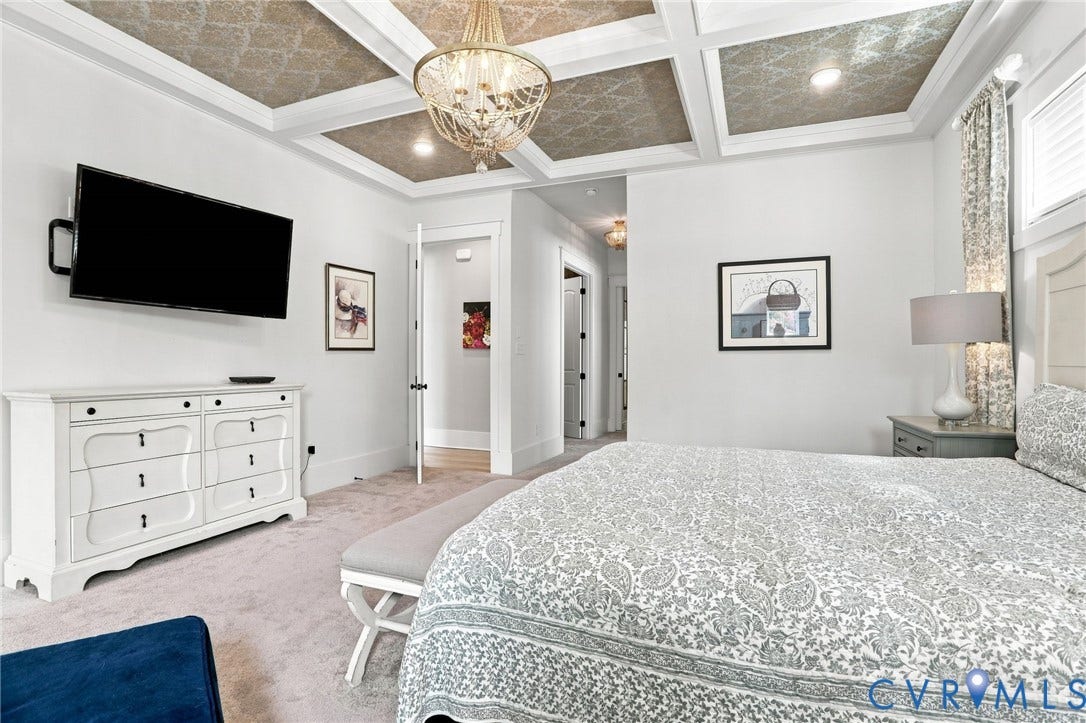 Coffer ceiling with patterned inlays, recessed lighting, and a prominent chandelier