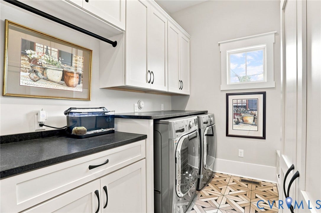 Laundry area featuring white cabinetry, dark countertops, wood-finish geometric pattern flooring, a window with natural light, and a black hanging rod