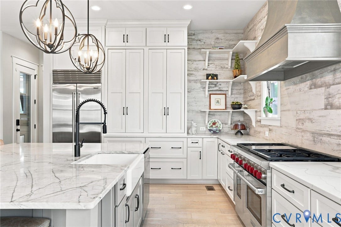 Bright kitchen featuring a substantial island with a farmhouse sink and modern faucet