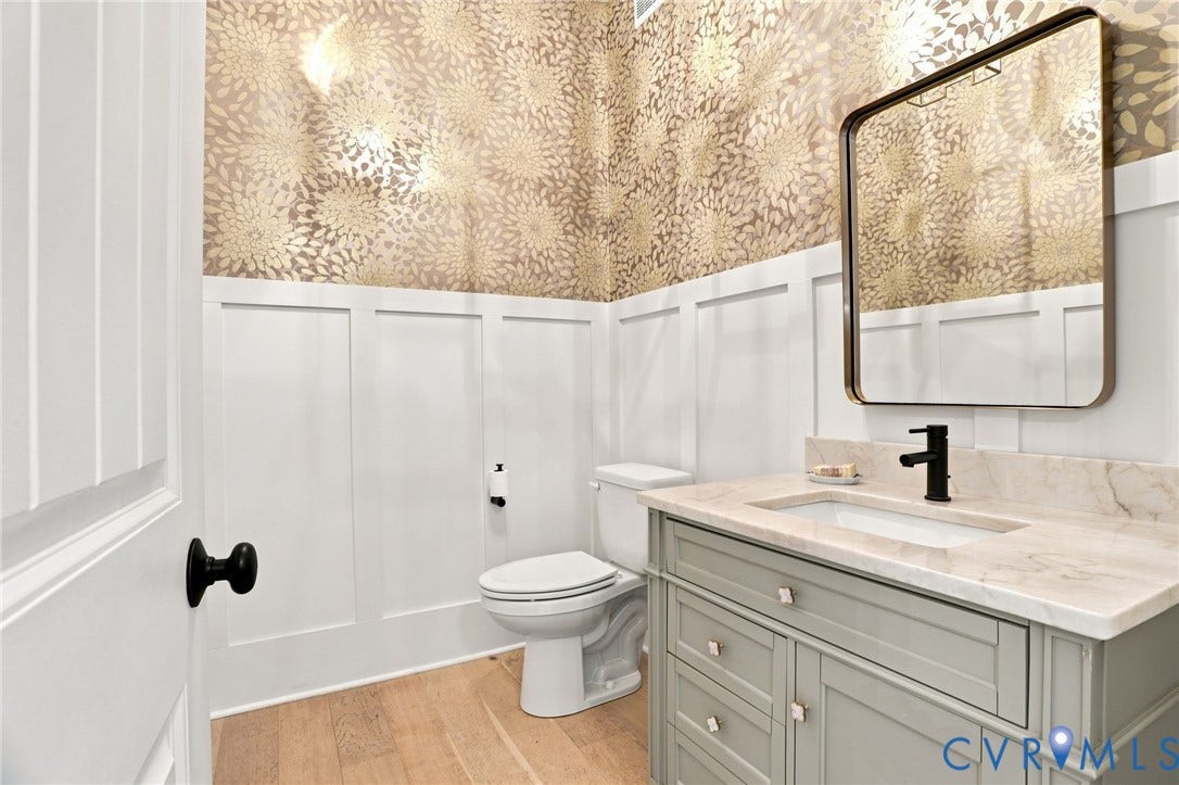Vanity with integrated sink, light-toned countertop, and matte black faucet