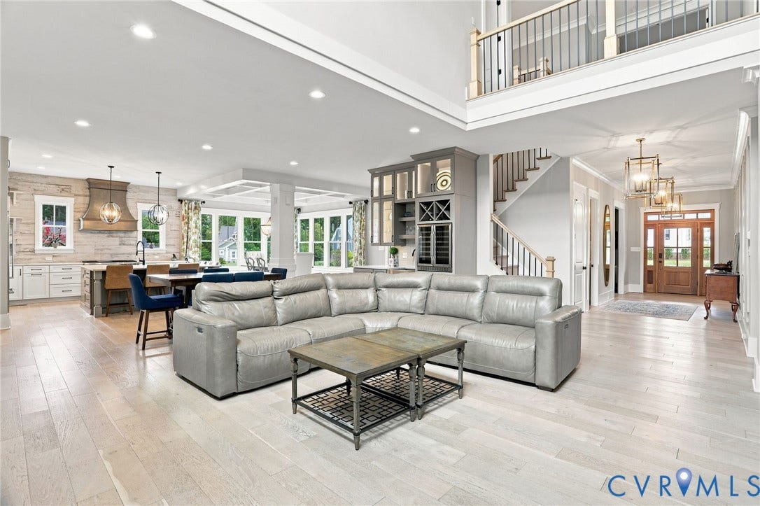 Spacious open-concept living area featuring light wood-finish flooring