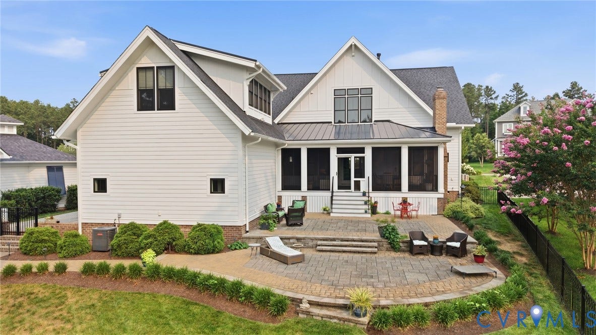 White siding exterior with black-framed windows, a screened porch, and a multi-level paver patio