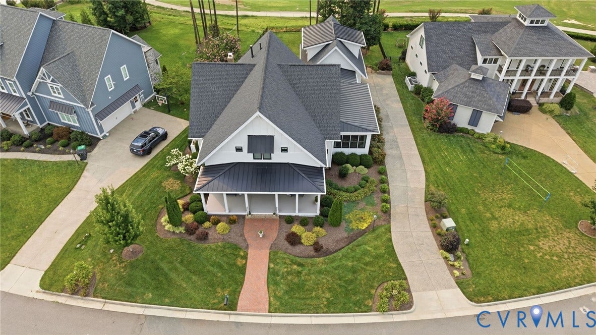 Modern farmhouse-style residence featuring a dark shingle roof, white board-and-batten siding, and a covered front porch with a dark metal awning