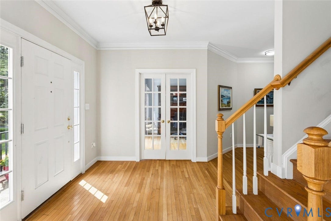 6001 Olde Hartley Place, Glen Allen, VA 23060 Hardwood flooring throughout, white French doors, detailed crown molding, a decorative lantern-style ceiling fixture, and a wood staircase with white balusters