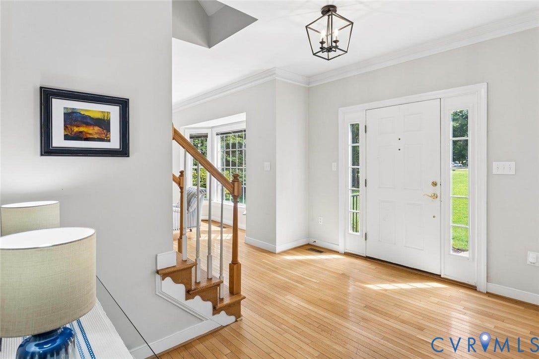 6001 Olde Hartley Place, Glen Allen, VA 23060 Bright entryway featuring wood-finish flooring, a white paneled front door with sidelights, a geometric flush-mount light fixture, and a staircase with wood newel posts and banister