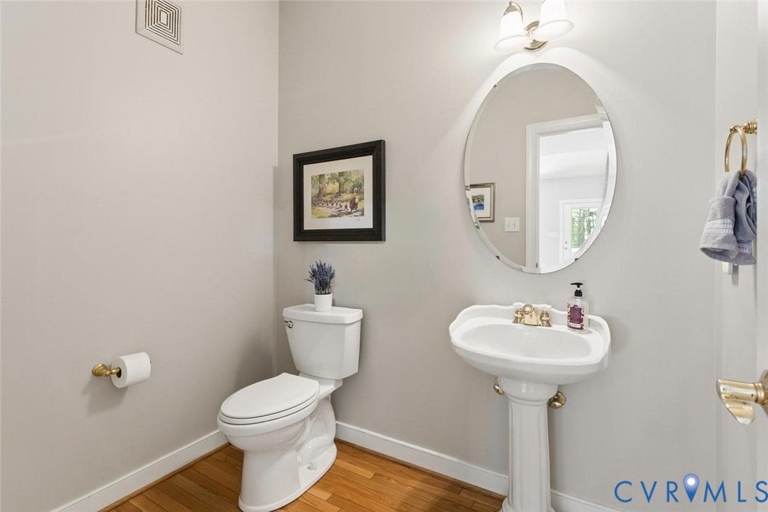 6001 Olde Hartley Place, Glen Allen, VA 23060 Pedestal sink, wall-mounted mirror, two-light vanity fixture, and wood-finish flooring