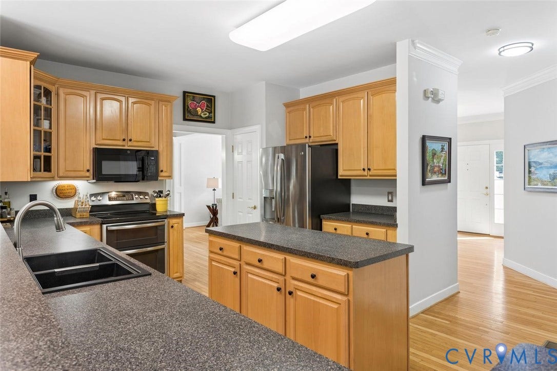 6001 Olde Hartley Place, Glen Allen, VA 23060 Kitchen featuring wood cabinetry, dark speckled countertops, stainless steel appliances, and a central island