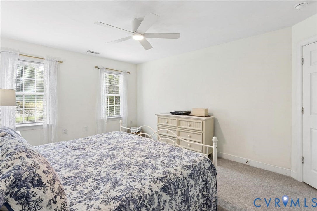 6001 Olde Hartley Place, Glen Allen, VA 23060 Two double-hung windows, neutral-toned carpeting, and a ceiling fan with integrated lighting