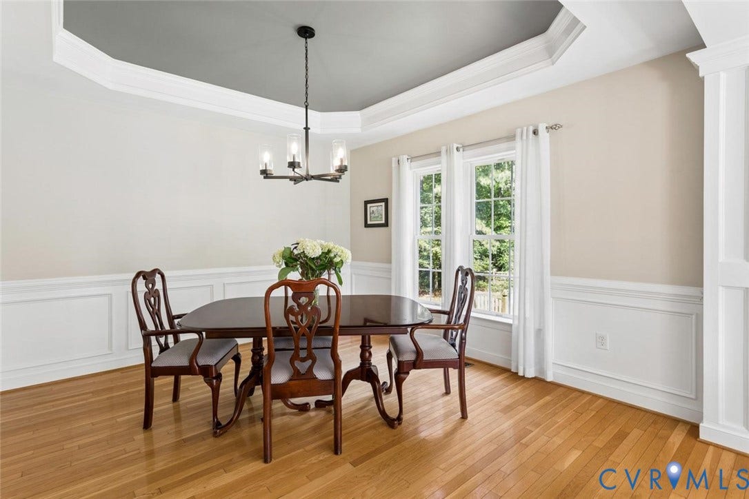 6001 Olde Hartley Place, Glen Allen, VA 23060 Tray ceiling with crown molding, chandelier, paneled wainscoting, hardwood flooring, and multiple windows