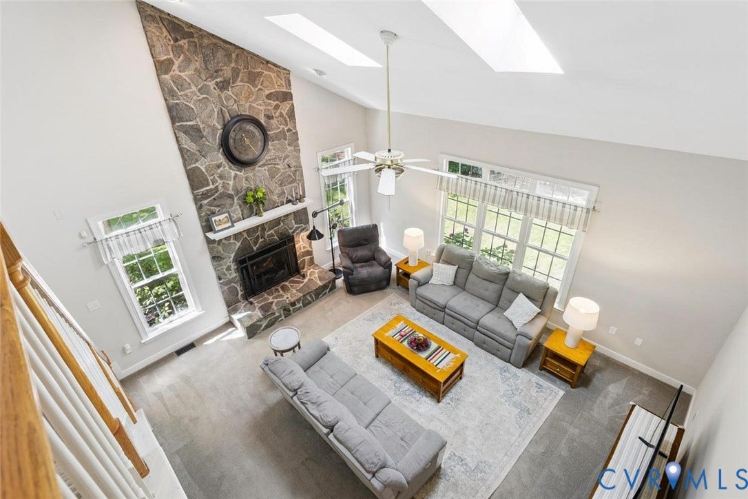 6001 Olde Hartley Place, Glen Allen, VA 23060 Two-story living area featuring a stone fireplace, high ceilings, multiple windows, and skylights