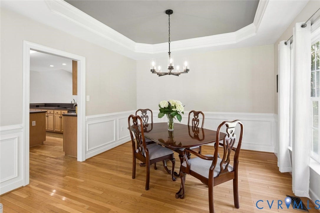 6001 Olde Hartley Place, Glen Allen, VA 23060 Tray ceiling with crown molding, chandelier, chair rail with wainscoting, wood-finish flooring, and a window with white trim