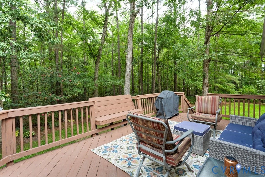 6001 Olde Hartley Place, Glen Allen, VA 23060 Expansive wooden deck featuring built-in bench seating and a natural treed backdrop