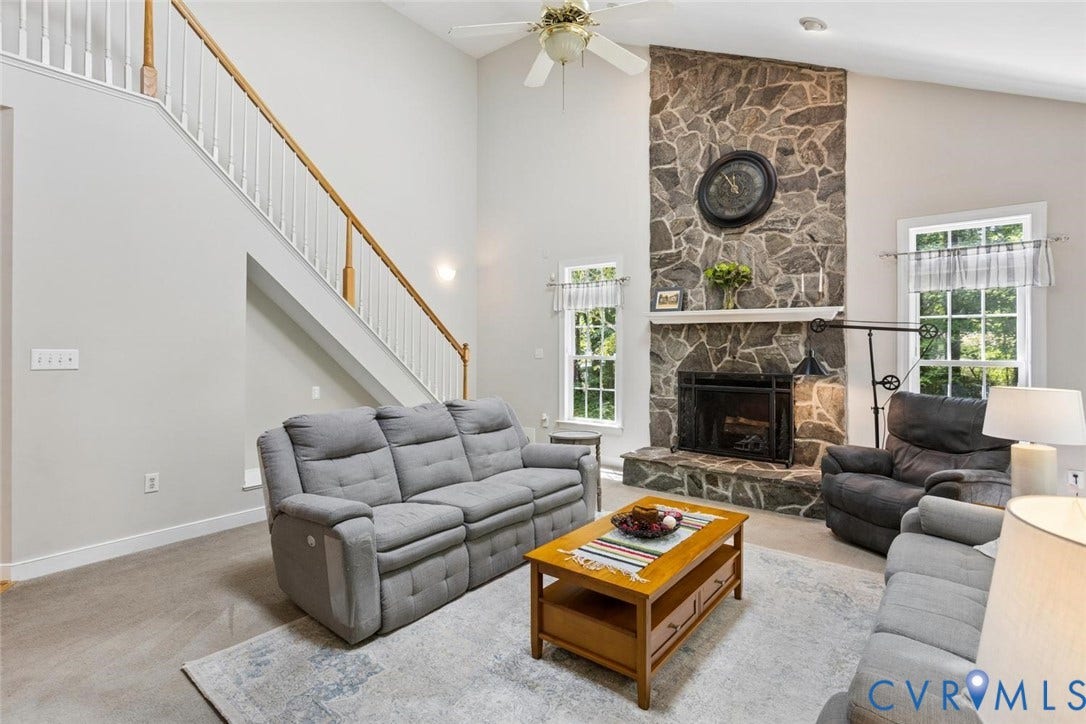 6001 Olde Hartley Place, Glen Allen, VA 23060 Vaulted ceiling, stone-clad fireplace with mantel, staircase with wood handrail, ceiling fan, and multiple windows