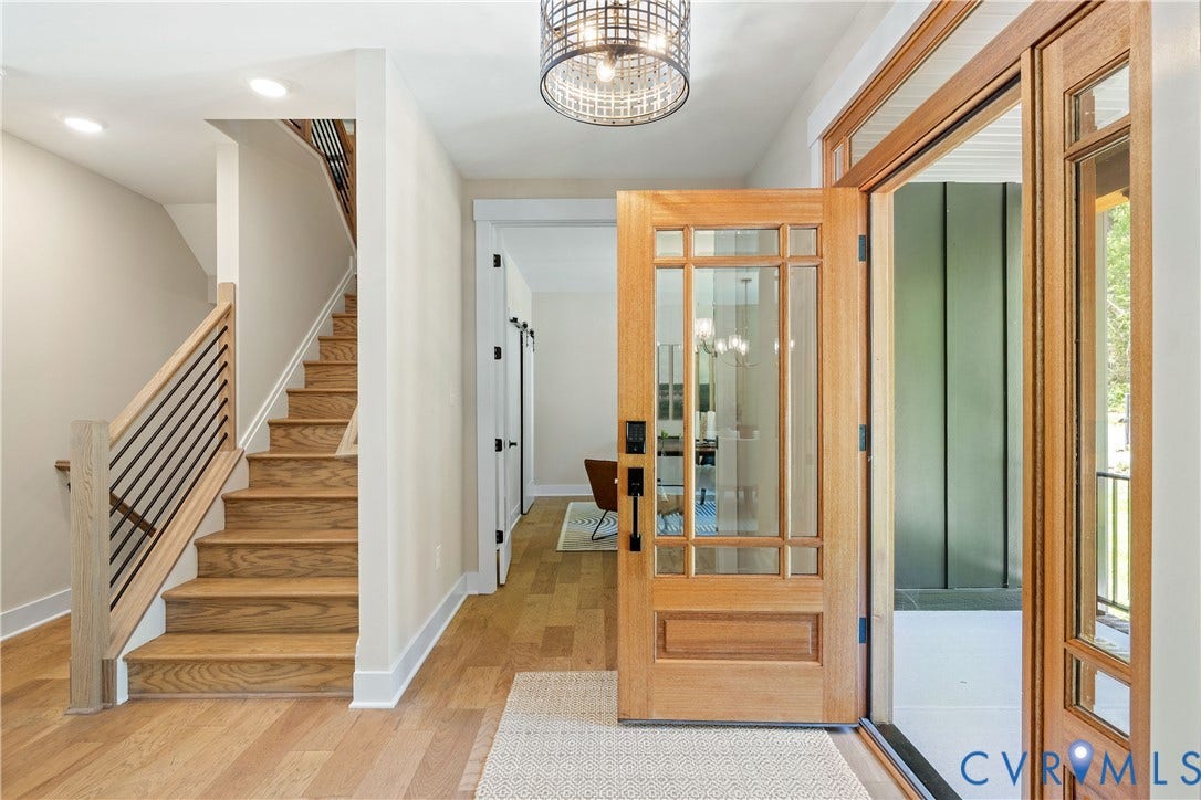 Hardwood flooring extending through the entry and up the staircase