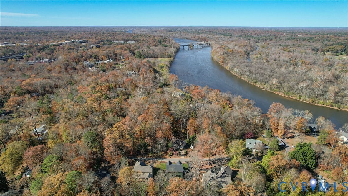 Expansive property featuring mature trees, a river, and a bridge