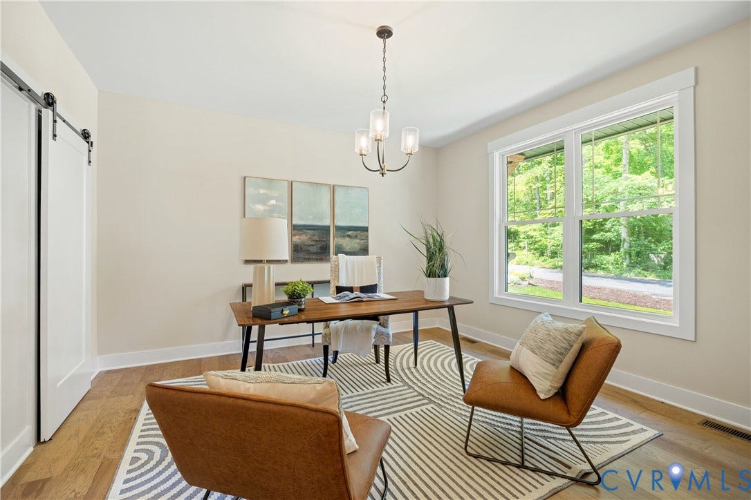 Room featuring wood-finish flooring, a contemporary chandelier, and a large window with white trim