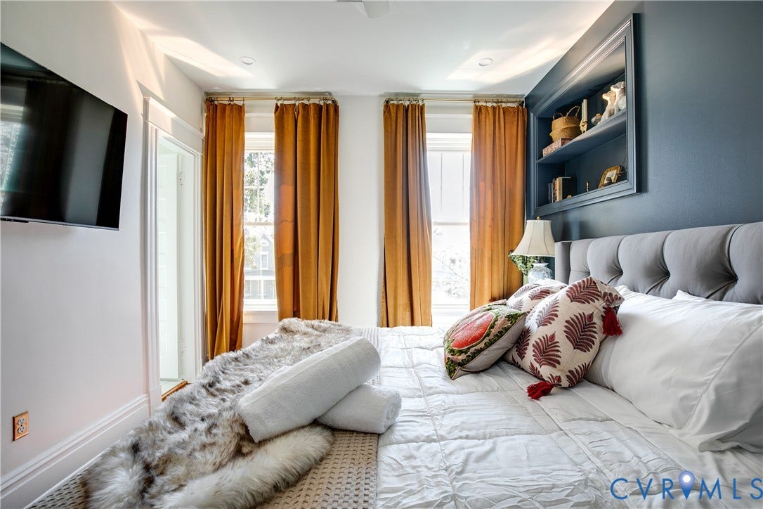 3142 Floyd Avenue, Museum District, Richmond, VA 23221 Spacious primary bedroom featuring an upholstered headboard, recessed ceiling lighting, and dual sets of floor-to-ceiling golden curtains framing expansive windows