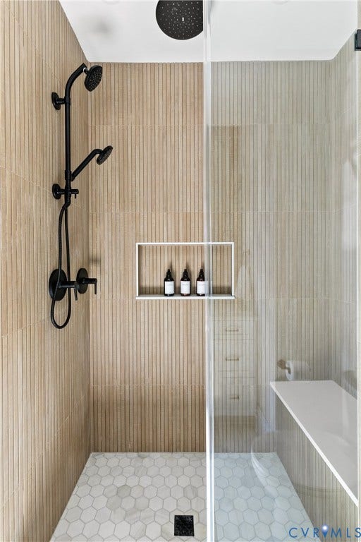 3142 Floyd Avenue, Museum District, Richmond, VA 23221 Shower enclosure featuring ribbon tiles, a rainfall showerhead, a handheld spray, a recessed niche, and a hexagonal floor tile pattern