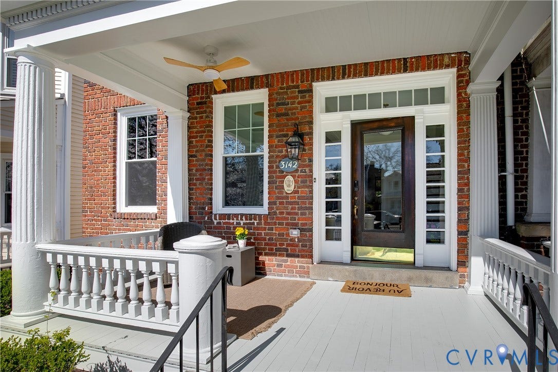 3142 Floyd Avenue, Museum District, Richmond, VA 23221 Brick exterior featuring a covered porch with white columns and railings, a dark wood-finish front door with glass panels, a transom window, and sidelights