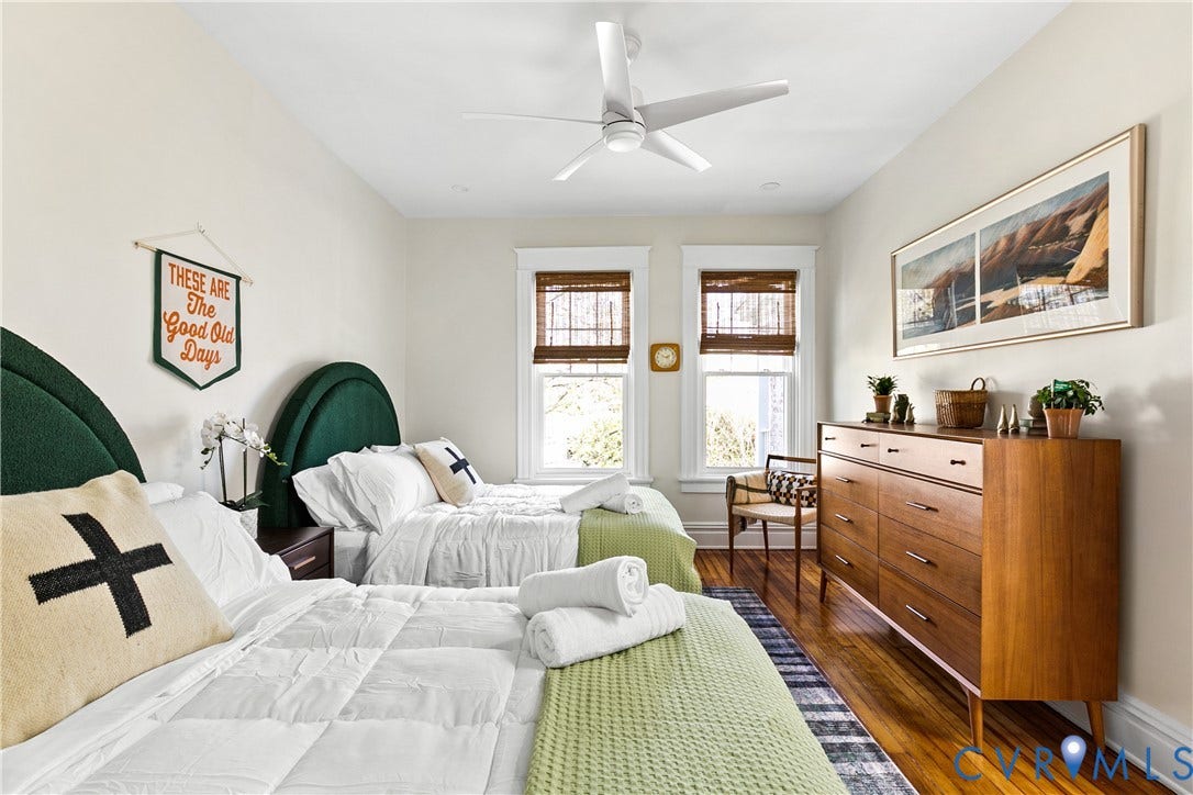 3142 Floyd Avenue, Museum District, Richmond, VA 23221 Bedroom featuring two beds with upholstered arched headboards, wood-finish flooring, two windows with woven wood blinds, and a ceiling fan