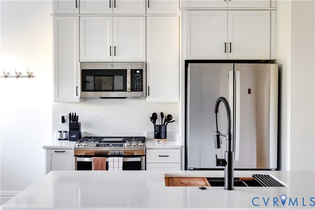 3142 Floyd Avenue, Museum District, Richmond, VA 23221 White shaker cabinetry with black hardware, stainless steel appliances, a gas range, and a deep undermount sink with a black coiled faucet