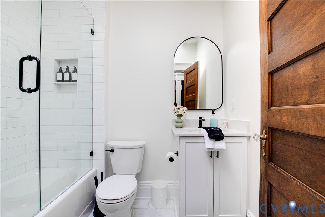 3142 Floyd Avenue, Museum District, Richmond, VA 23221 Bathroom featuring a white subway tile shower with a recessed niche, clear glass enclosure, and matte black fixtures
