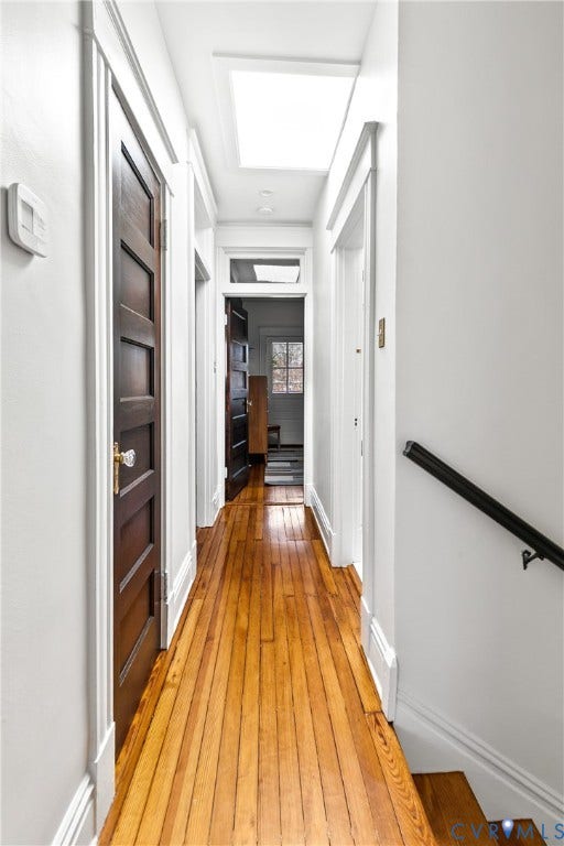 3142 Floyd Avenue, Museum District, Richmond, VA 23221 Hallway featuring wood-finish flooring, white trim, dark wood doors with glass knobs, overhead skylight, and recessed lighting