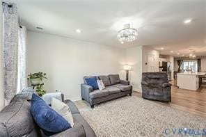 7225 Lyon Taylor Lane, The Groves At New Kent, New Kent, VA 23124 Spacious living area featuring wood-finish flooring, recessed lighting, and an elegant chandelier