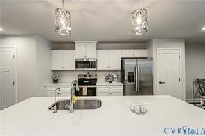 7225 Lyon Taylor Lane, The Groves At New Kent, New Kent, VA 23124 Modern kitchen featuring a spacious island with an undermount sink and a high-arc faucet, stainless steel appliances, white cabinetry, and decorative pendant lighting
