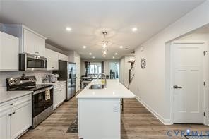 7225 Lyon Taylor Lane, The Groves At New Kent, New Kent, VA 23124 Contemporary kitchen featuring white cabinetry, stainless steel appliances, a white subway tile backsplash, and a large island with an integrated sink
