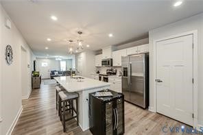 7225 Lyon Taylor Lane, The Groves At New Kent, New Kent, VA 23124 Open-concept kitchen featuring an island with seating, white cabinetry, stainless steel appliances, and recessed lighting
