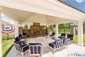 7225 Lyon Taylor Lane, The Groves At New Kent, New Kent, VA 23124 Covered patio featuring a stone-clad outdoor fireplace, a ceiling fan, and recessed lighting