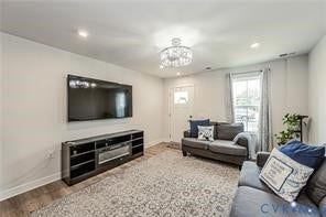 7225 Lyon Taylor Lane, The Groves At New Kent, New Kent, VA 23124 Spacious living area featuring light-toned walls, wood-finish flooring, recessed lighting, a modern chandelier, and a large window providing natural illumination