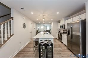 7225 Lyon Taylor Lane, The Groves At New Kent, New Kent, VA 23124 Elongated kitchen featuring an island with seating, stainless steel appliances, and white cabinetry