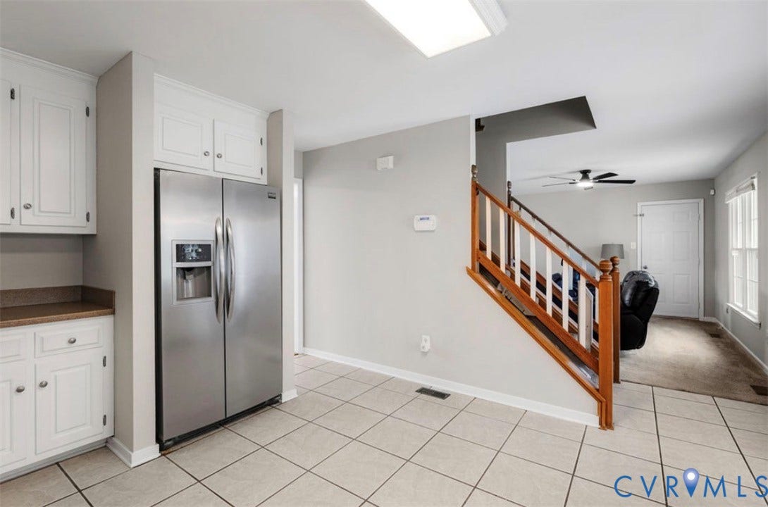2912 Appleford Drive, Longmeadow, Chester, VA 23831 Stainless steel refrigerator, white cabinetry, tile flooring, wood staircase, and recessed lighting