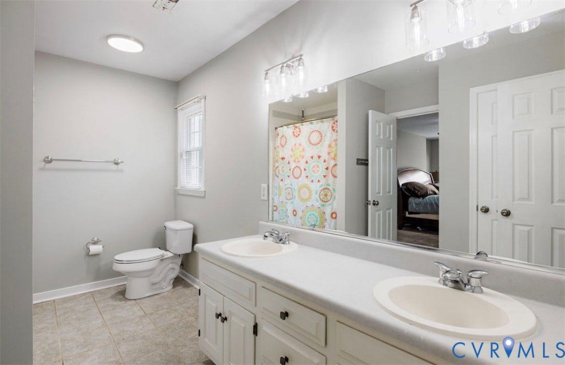 2912 Appleford Drive, Longmeadow, Chester, VA 23831 Dual vanity with white cabinetry, tile flooring, built-in mirror, and window