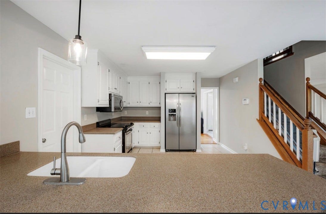 2912 Appleford Drive, Longmeadow, Chester, VA 23831 Kitchen featuring white cabinetry, stainless steel appliances, a double basin sink, and a staircase with wood newel posts and handrails