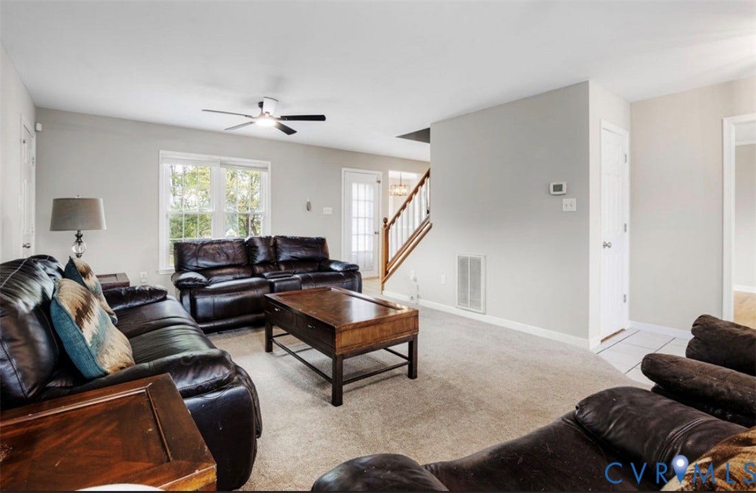 2912 Appleford Drive, Longmeadow, Chester, VA 23831 Spacious living area featuring neutral carpeting, a ceiling fan with integrated lighting, and multiple windows