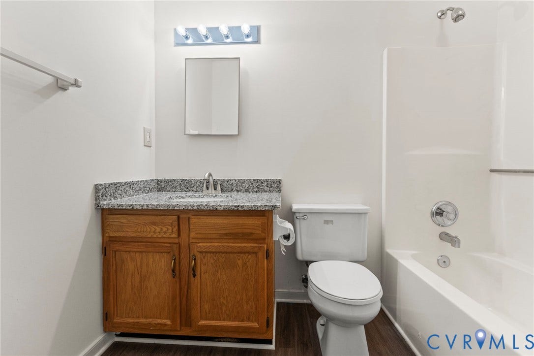 10111 Robin Lee Lane, Henrico, VA 23060 Bathroom featuring wood-finish vanity with granite-style countertop, integrated sink, and chrome fixtures