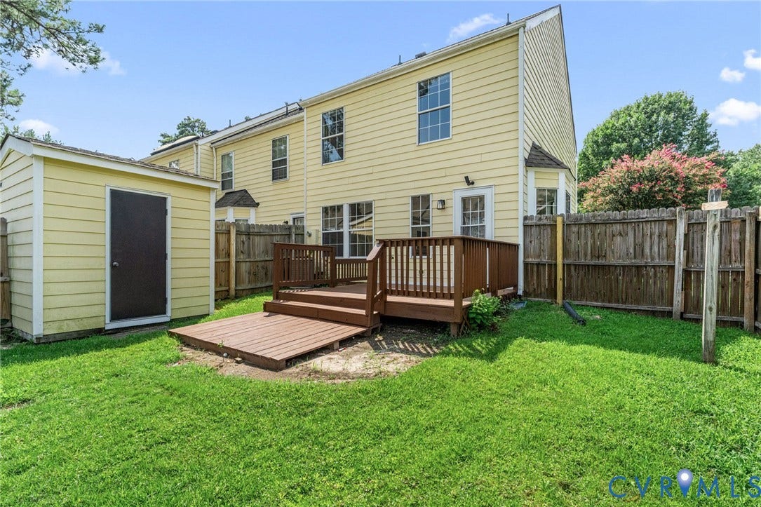10111 Robin Lee Lane, Henrico, VA 23060 Expansive backyard oasis featuring a composite multi-level deck with integrated seating areas, manicured lawn, mature landscaping with flowering trees, and wooden privacy fencing