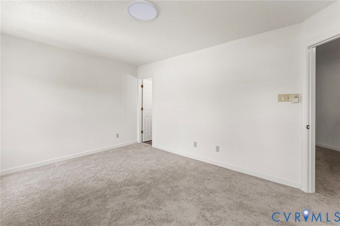 10111 Robin Lee Lane, Henrico, VA 23060 Spacious bedroom with neutral wall finishes, plush carpeting throughout, and abundant natural light from ceiling fixtures