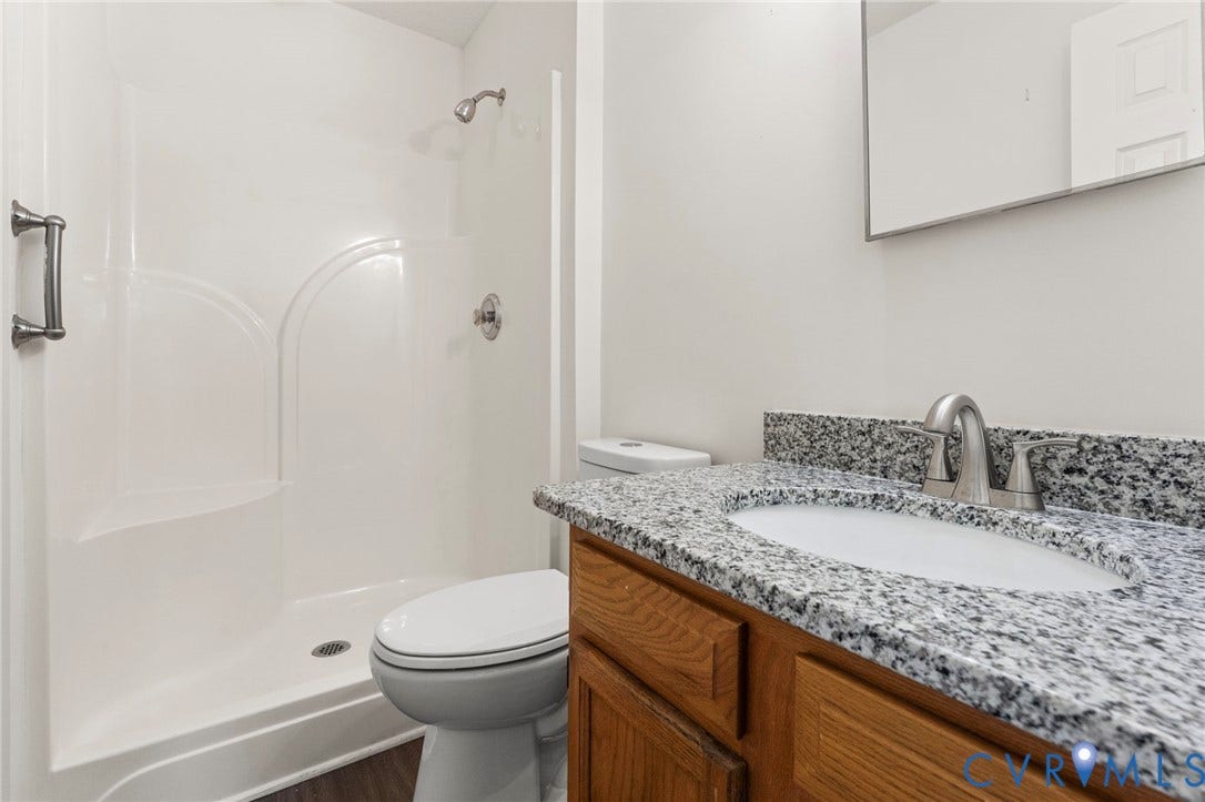 10111 Robin Lee Lane, Henrico, VA 23060 Contemporary vanity featuring granite-style countertop, oval undermount sink, brushed nickel faucet, and wood-finish cabinetry