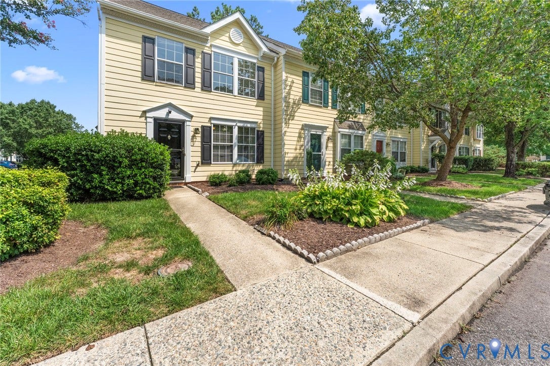 10111 Robin Lee Lane, Henrico, VA 23060 Yellow siding exterior with black shutters, mature landscaping, concrete sidewalk, and curb